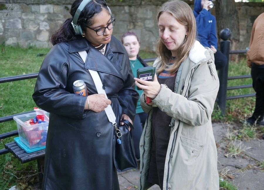Two people discussing an outdoor activity beside fieldwork equipment.